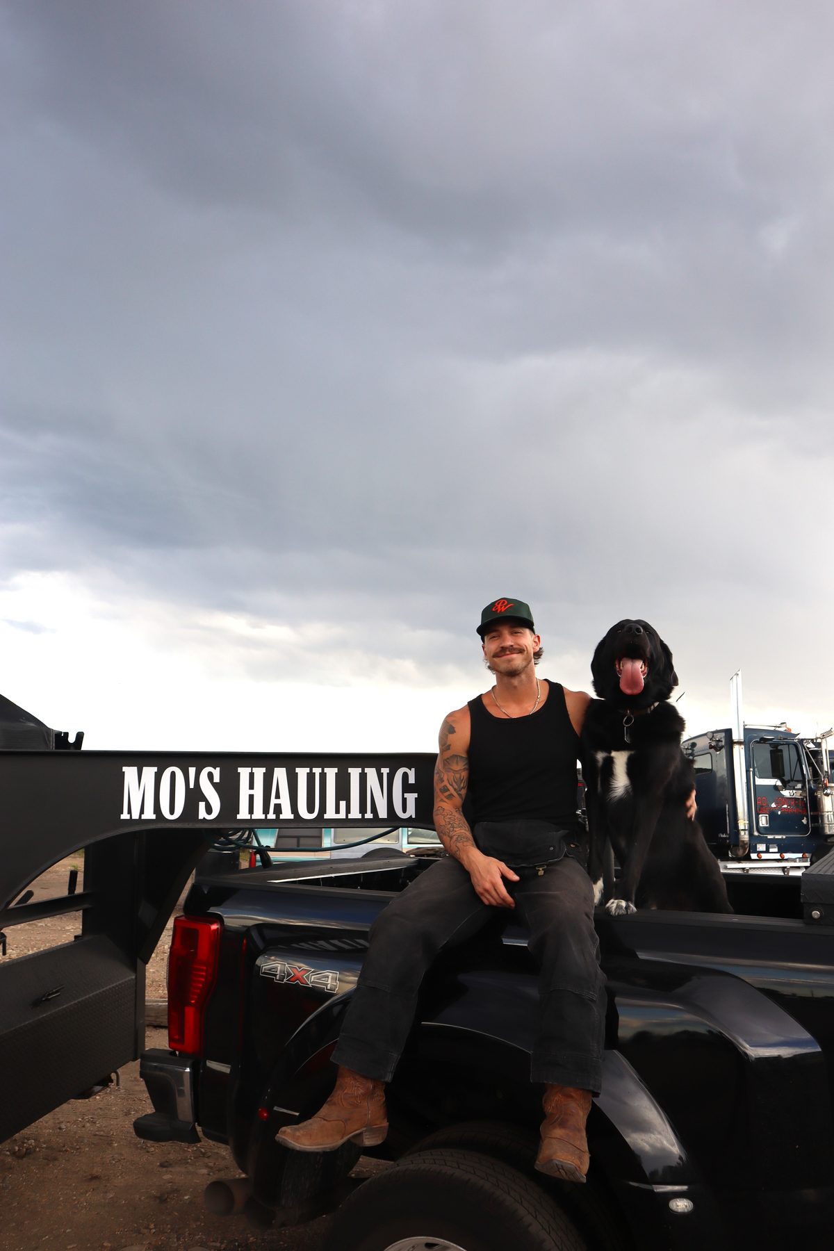 Eric sitting on the bed of the Mo's Hauling truck with Mosley