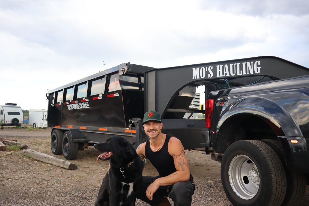 Eric kneeling with Mosley in front of the Mo's Hauling dump trailer